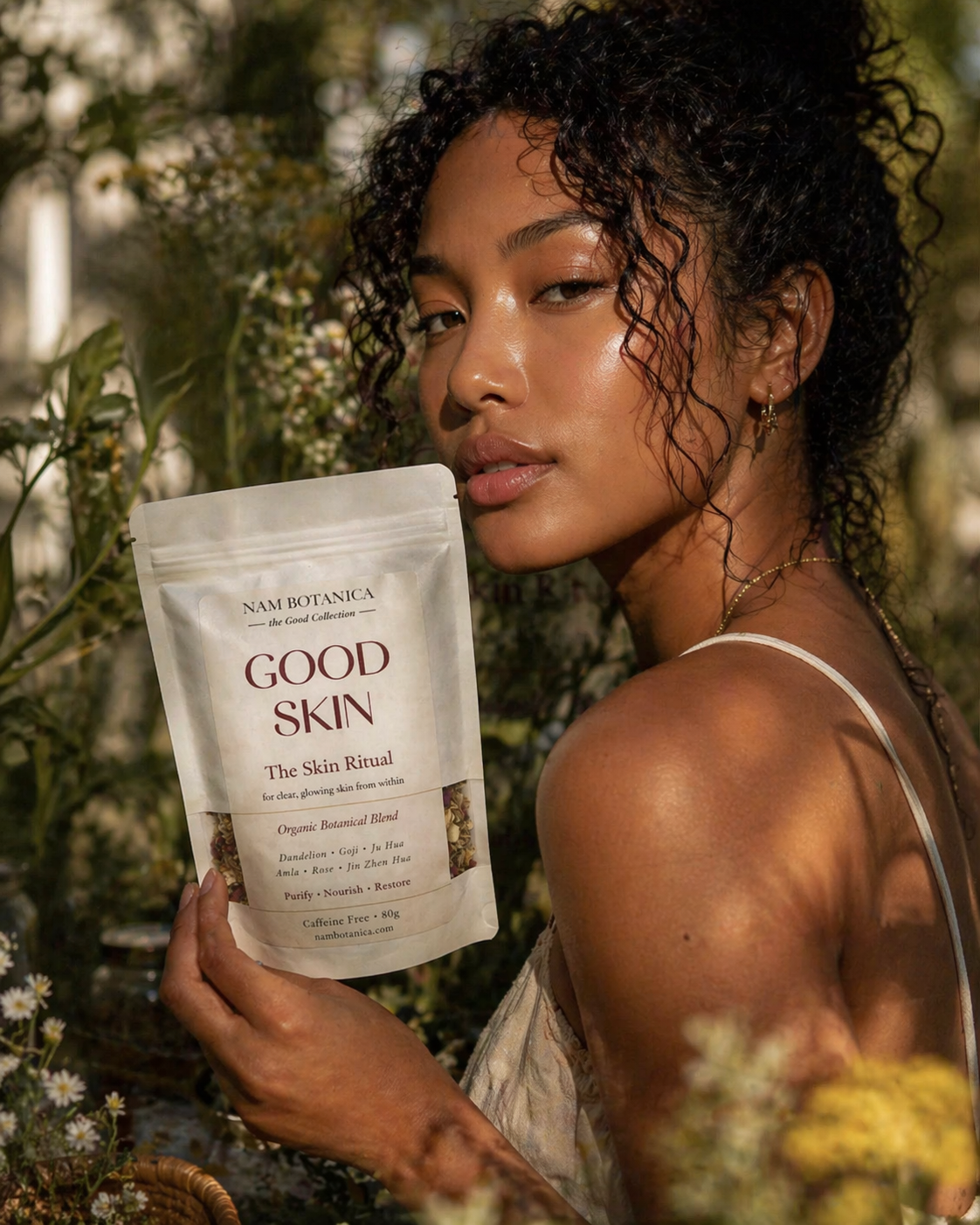 Nam Botanica Good Skin Tea – woman with clear glowing skin holding The Skin Ritual organic botanical blend, caffeine free herbal tea for skin health and traditional Chinese medicine